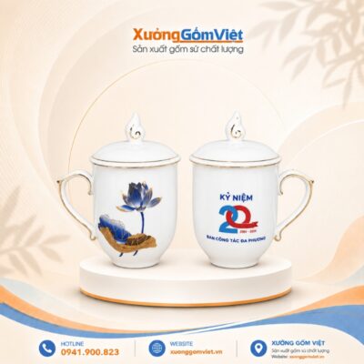 Cốc sứ in logo Kỷ niệm 20 năm Ban công tác Đa Phương dáng bầu có nắp màu trắng họa tiết sen xanh kẻ chỉ vàng M177